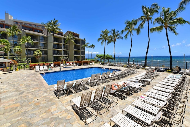 view of pool featuring a patio area and a water view