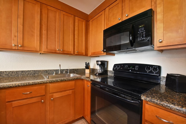 kitchen featuring black appliances, dark stone countertops, and sink