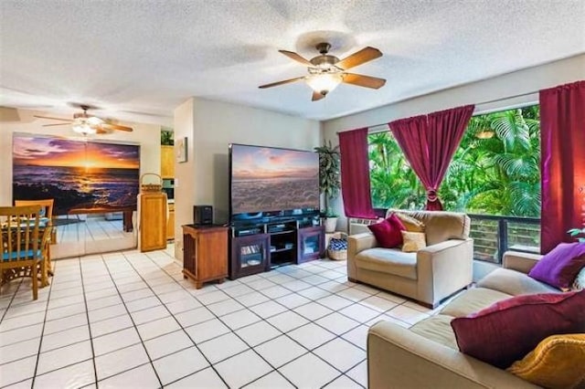 living room with ceiling fan, a textured ceiling, and light tile patterned floors