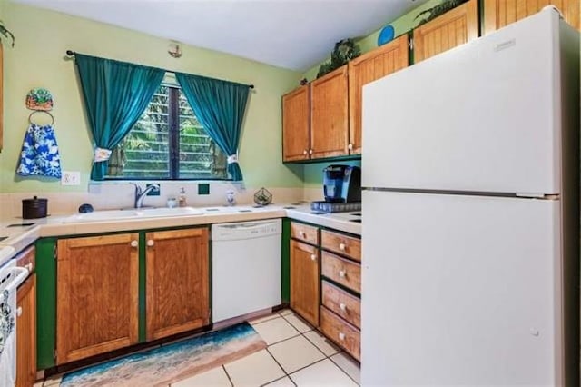 kitchen featuring light tile patterned floors, white appliances, and sink