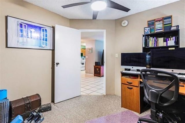 office space featuring a textured ceiling, light colored carpet, and ceiling fan