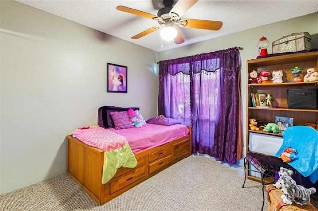 carpeted bedroom featuring a textured ceiling and ceiling fan