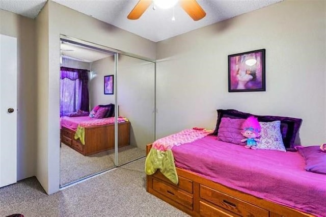 bedroom with light colored carpet, ceiling fan, and a closet