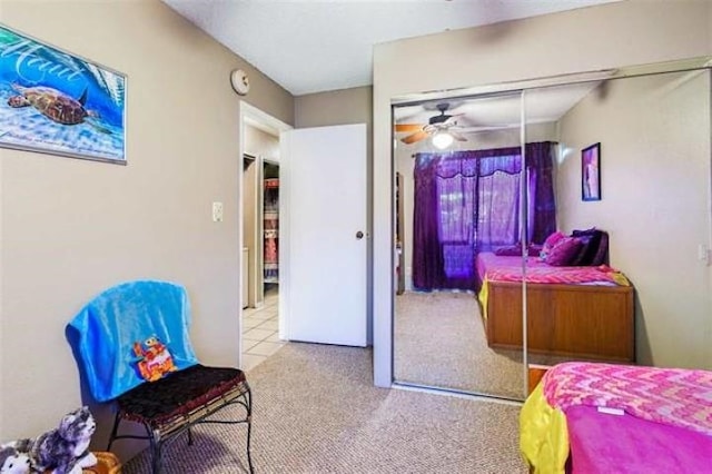 carpeted bedroom featuring ceiling fan and a closet