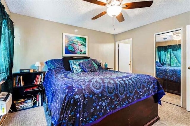 carpeted bedroom with ceiling fan and a textured ceiling