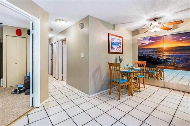 dining area featuring ceiling fan, a textured ceiling, and light tile patterned floors