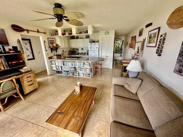 living room featuring ceiling fan, a textured ceiling, and light tile patterned floors