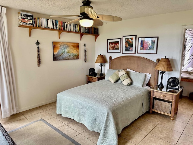 bedroom with ceiling fan, light tile patterned floors, and a textured ceiling