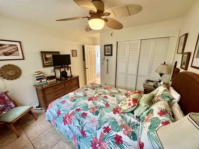 tiled bedroom with ceiling fan and a closet