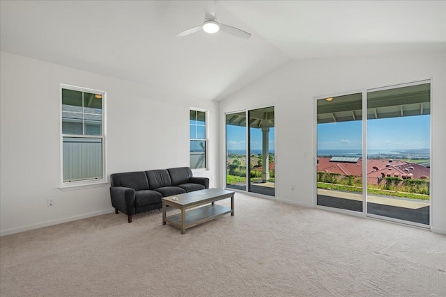 living area featuring carpet, a wealth of natural light, vaulted ceiling, and a ceiling fan
