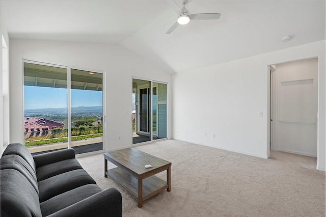living room featuring vaulted ceiling, carpet, baseboards, and a ceiling fan