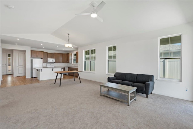living room featuring light carpet, recessed lighting, plenty of natural light, and vaulted ceiling