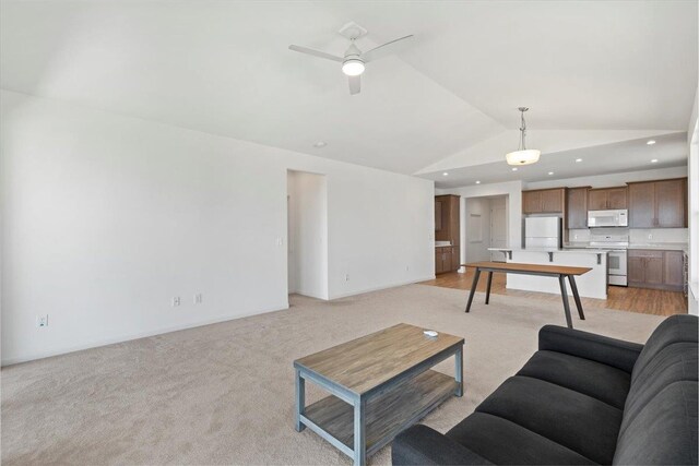 living room featuring lofted ceiling, light colored carpet, a ceiling fan, and baseboards