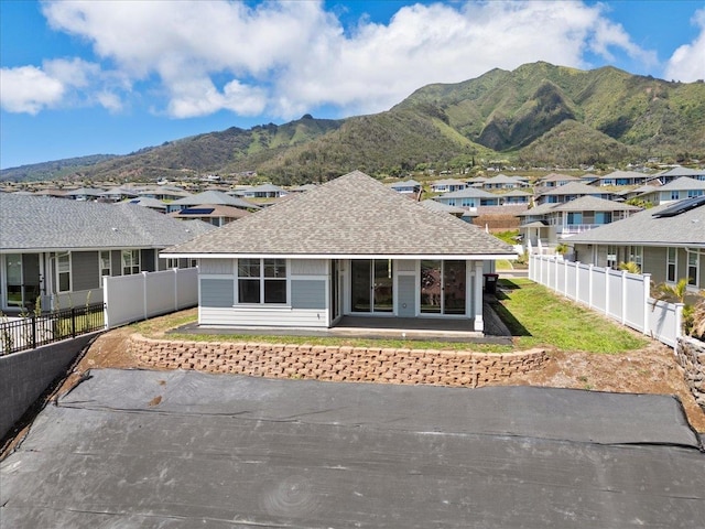 view of front of house featuring roof with shingles, a mountain view, and a residential view