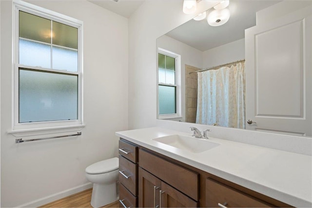full bathroom featuring toilet, wood finished floors, vanity, a shower with shower curtain, and baseboards