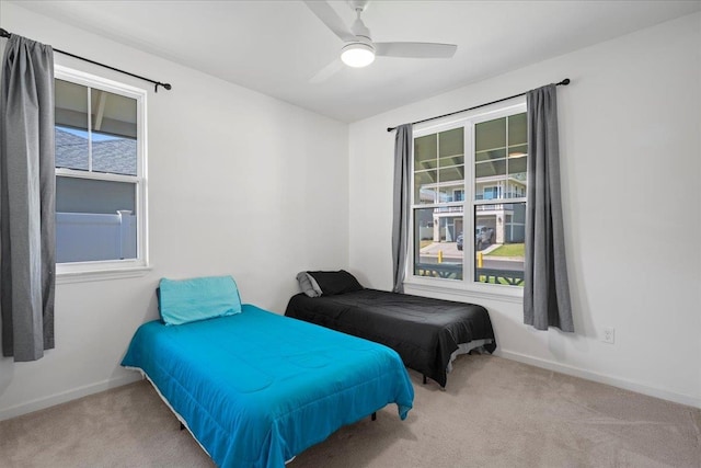 carpeted bedroom with baseboards and a ceiling fan