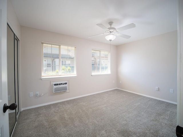 carpeted empty room with a wall mounted AC and ceiling fan