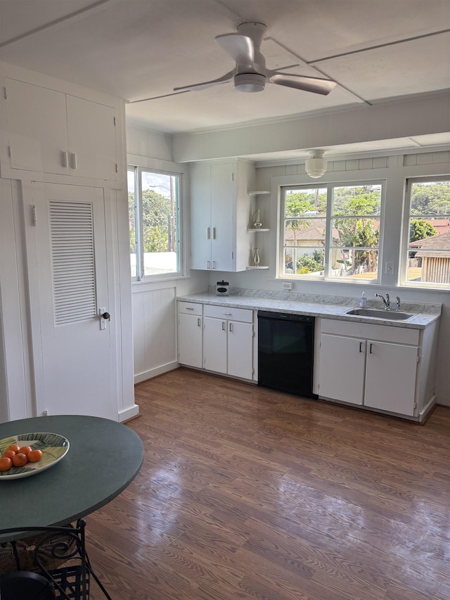 kitchen with dark wood-type flooring, a sink, white cabinets, light countertops, and dishwasher