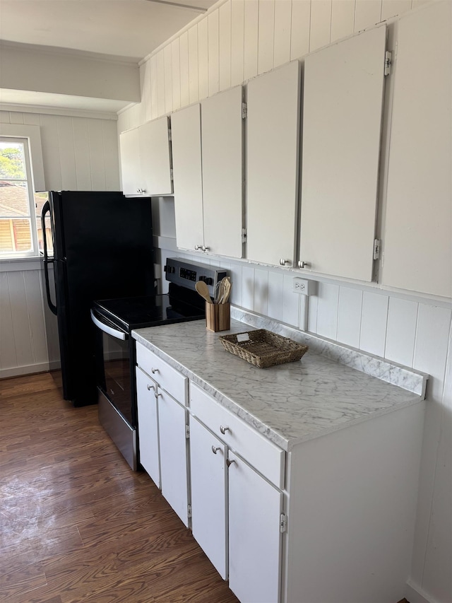 kitchen featuring dark wood-type flooring, ornamental molding, freestanding refrigerator, electric stove, and white cabinets