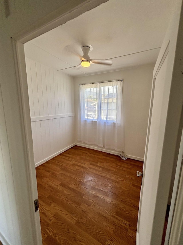 unfurnished room featuring wood finished floors, baseboards, and ceiling fan