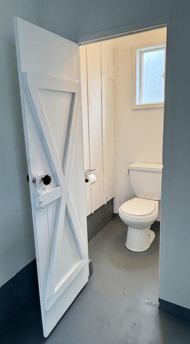 bathroom featuring toilet and concrete floors