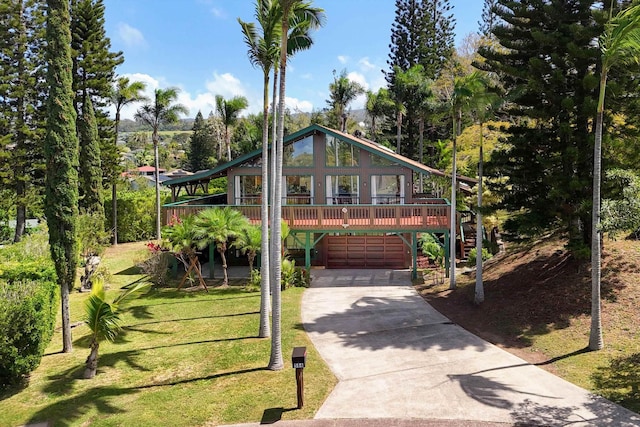 exterior space with stairway, a front yard, a garage, and driveway