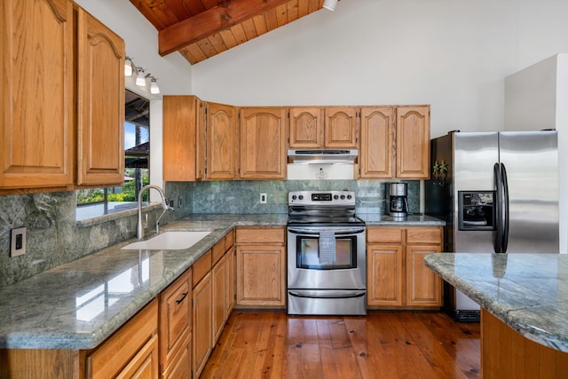 kitchen featuring a sink, under cabinet range hood, appliances with stainless steel finishes, beamed ceiling, and tasteful backsplash