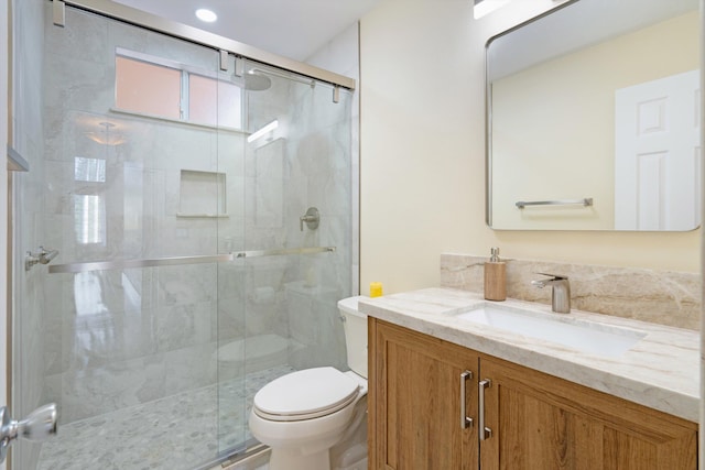 full bath with vanity, toilet, and a stall shower