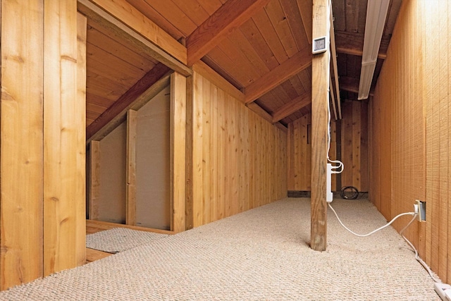 bonus room featuring lofted ceiling with beams, wooden walls, wood ceiling, and carpet