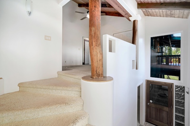 stairs with beamed ceiling, high vaulted ceiling, ceiling fan, and carpet flooring