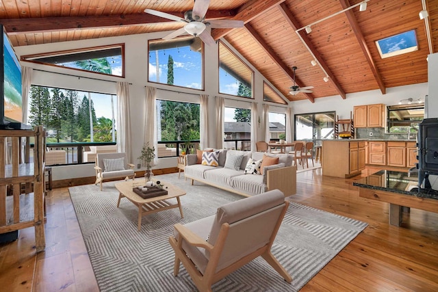 living area with beamed ceiling, wood ceiling, and light wood-style floors