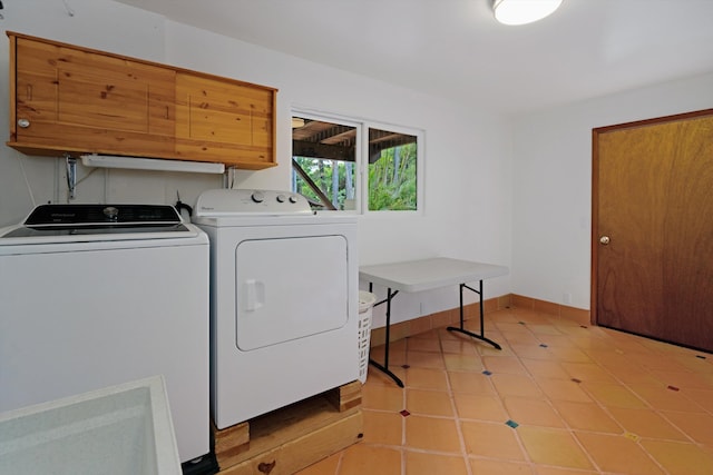 clothes washing area with laundry area, separate washer and dryer, and baseboards