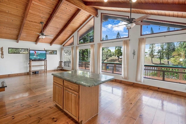 kitchen with a kitchen island, high vaulted ceiling, ceiling fan, light wood-style floors, and beamed ceiling