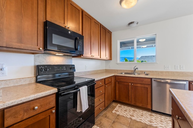 kitchen with decorative backsplash, light tile patterned floors, sink, and black appliances