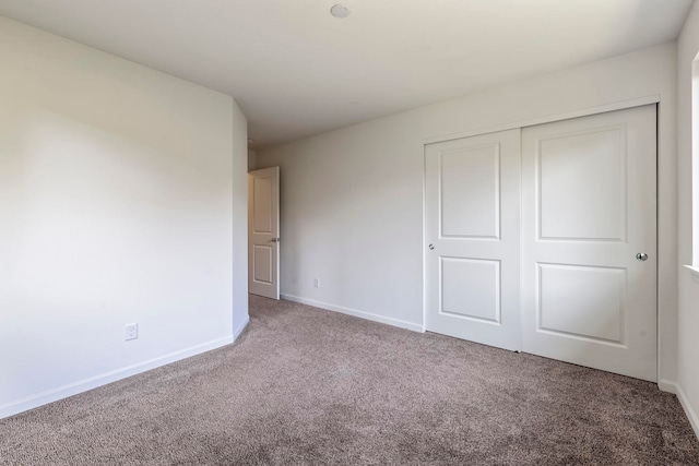 unfurnished bedroom featuring carpet and a closet