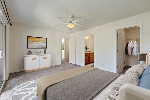 bedroom with ensuite bath, ceiling fan, light colored carpet, a walk in closet, and a closet