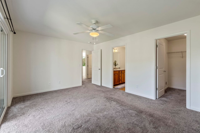 unfurnished bedroom with carpet flooring, ceiling fan, a walk in closet, and a closet