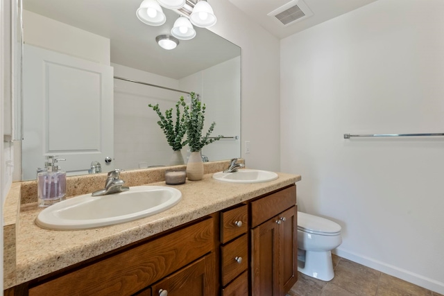 bathroom with tile patterned flooring, vanity, and toilet