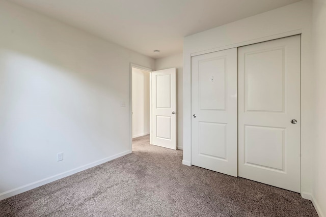 unfurnished bedroom featuring carpet and a closet