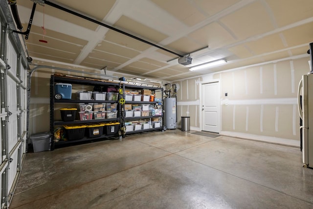 garage featuring gas water heater, a garage door opener, and stainless steel refrigerator