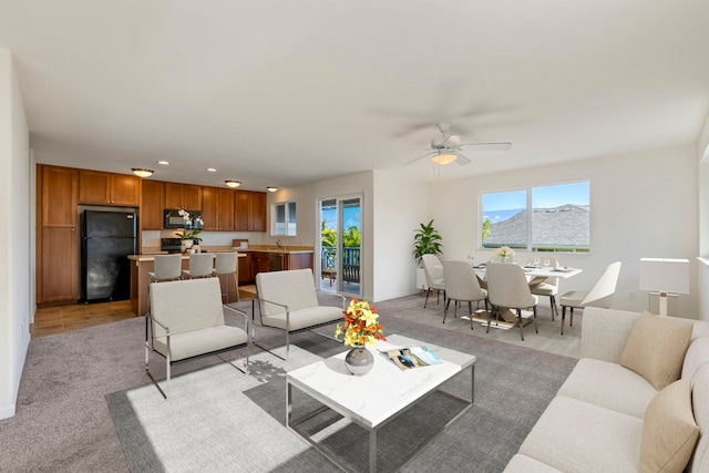 living room with light carpet and ceiling fan