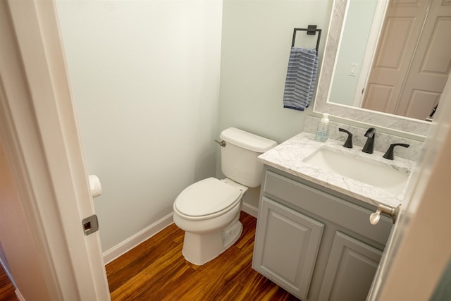 bathroom with vanity, toilet, and hardwood / wood-style floors