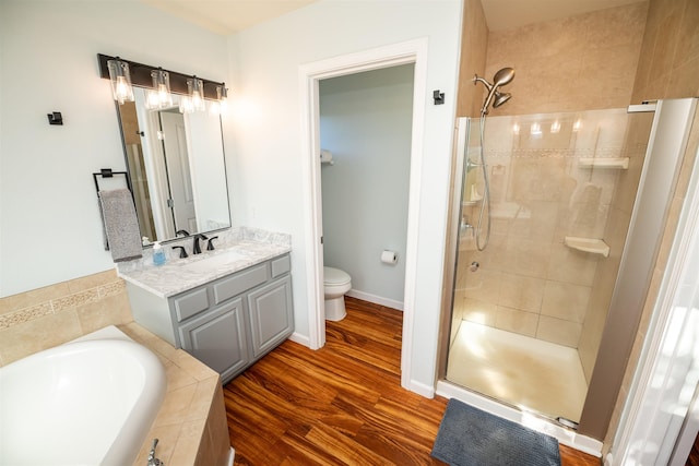 full bathroom with independent shower and bath, wood-type flooring, vanity, and toilet