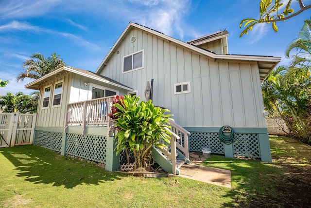 back of property featuring a yard and a deck