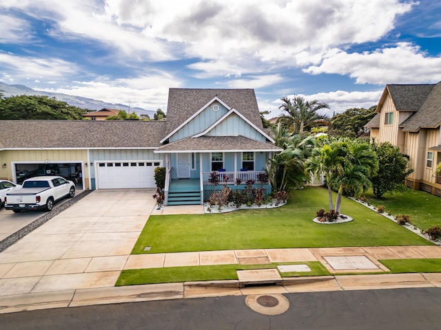 view of front of property with a garage, a mountain view, covered porch, and a front yard