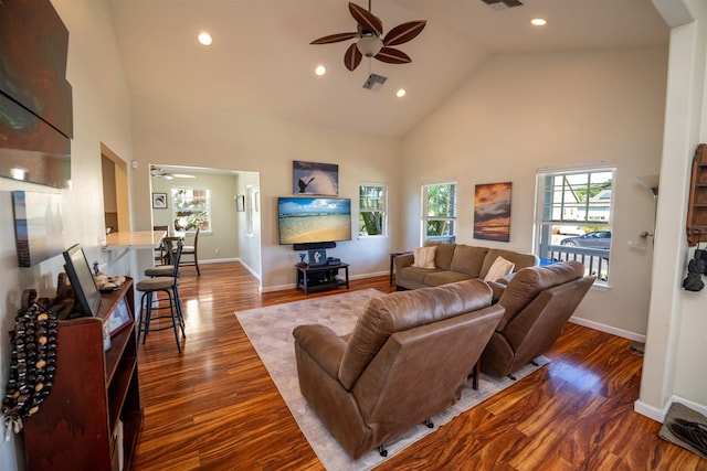 living room featuring dark wood-type flooring, ceiling fan, plenty of natural light, and high vaulted ceiling