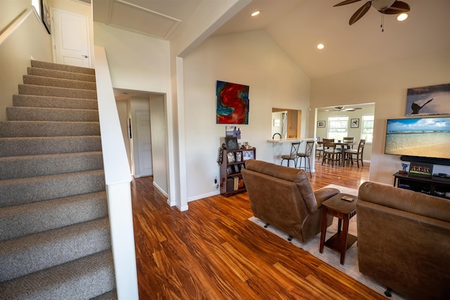 living room with dark hardwood / wood-style flooring, ceiling fan, and high vaulted ceiling