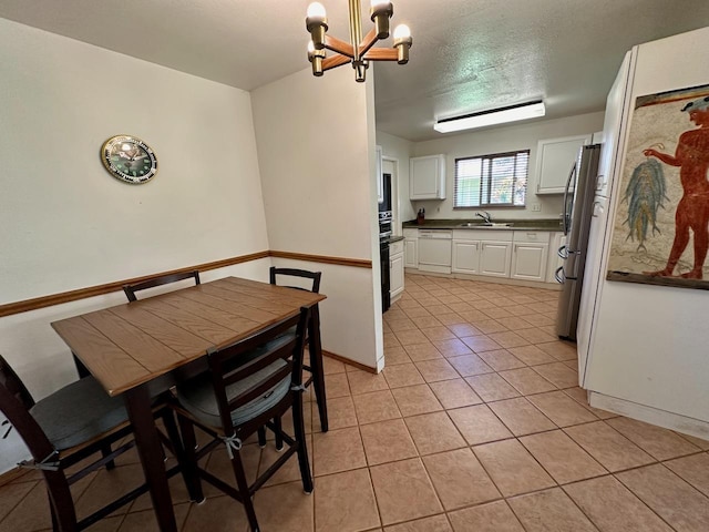 dining area featuring sink, light tile patterned flooring, and an inviting chandelier