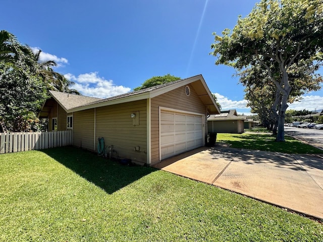 view of side of property featuring a garage, an outbuilding, and a lawn