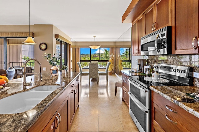 50 Nohea Kai Dr Unit 2-702, Lahaina, HI 96761 - kitchen featuring stainless steel appliances, brown cabinets, decorative backsplash, and pendant lighting